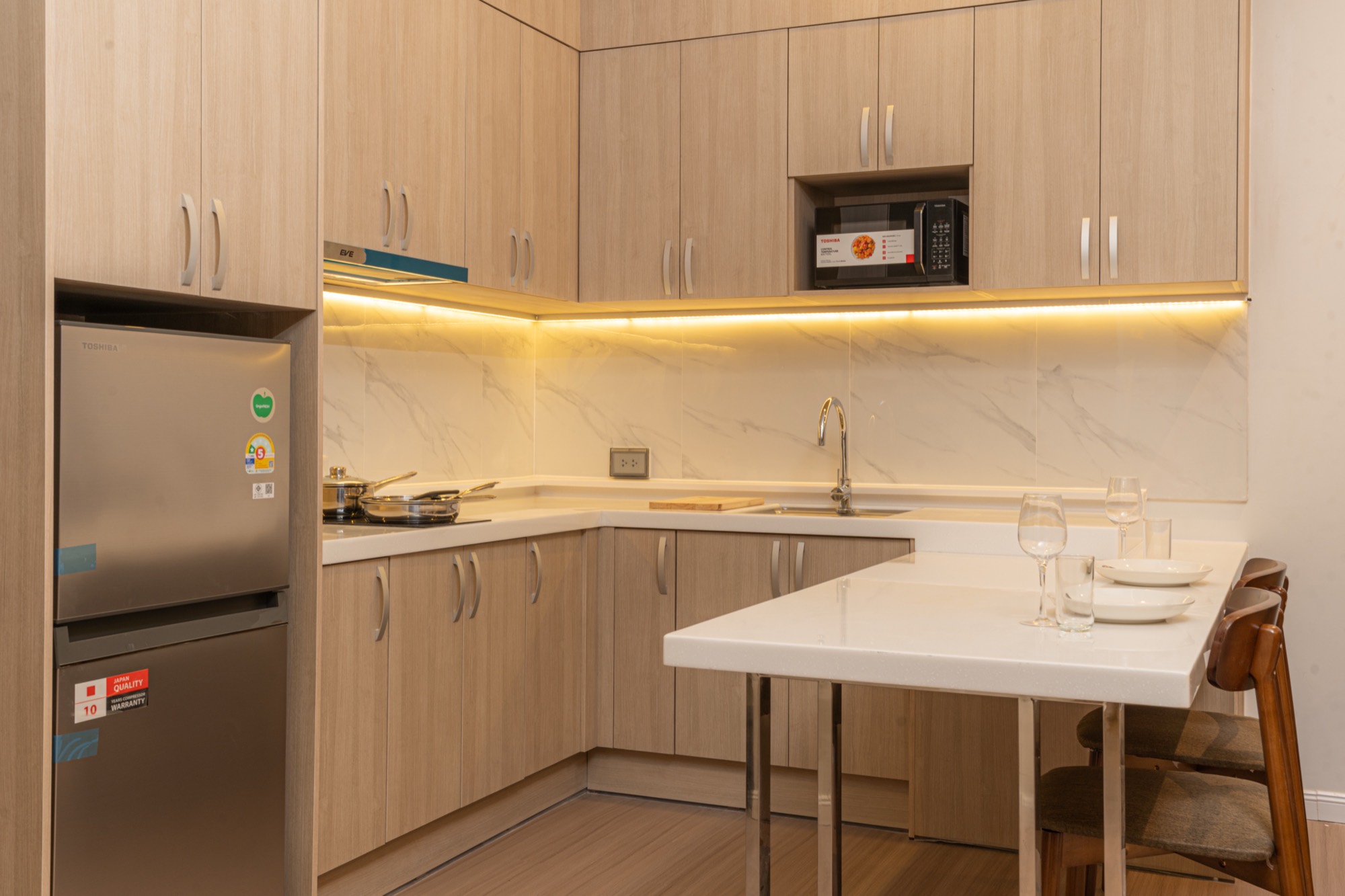 In-suite kitchen with marble counter and breakfast bar